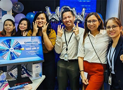 OpenText employees standing behind a computer