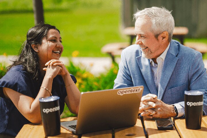 Two people sitting outside at a bench