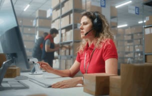 person on computer in a warehouse
