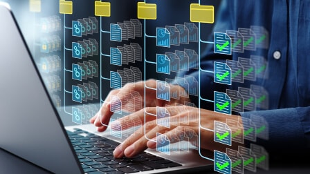 A person working on laptop with holographic digital file icons