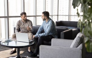 Two people sitting on couch and talking