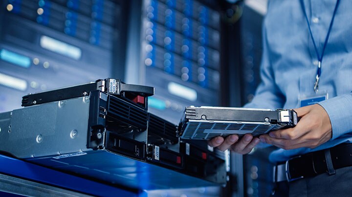 A person inserting a hard disk into the CPU
