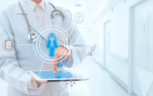 Healthcare professional using a tablet with digital medical icons in a hospital hallway.