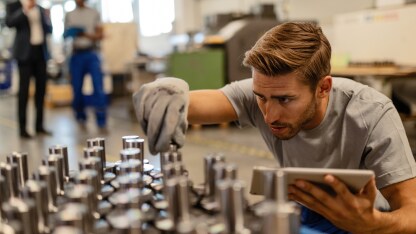 Person wearing safety gloves checking production