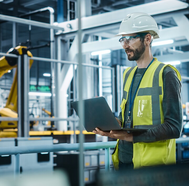 A person looking at a laptop in manufacturing units