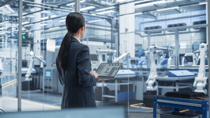 Business woman looking out over manufacturing floor