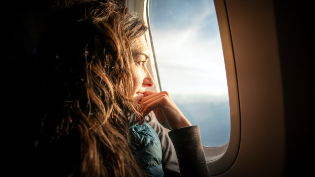 Woman looking out of an airplane window