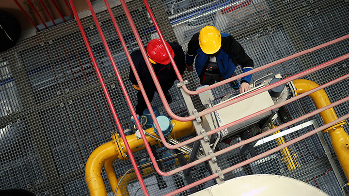 Overhead of two people on industrial site wearing hard hats