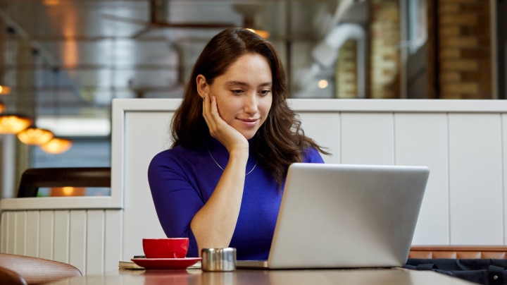 Woman in a cafe reading on her laptop