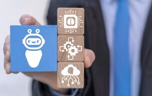 Close-up on wooden blocks with gears and a robot with the letters RPA for Robotic Process Automation